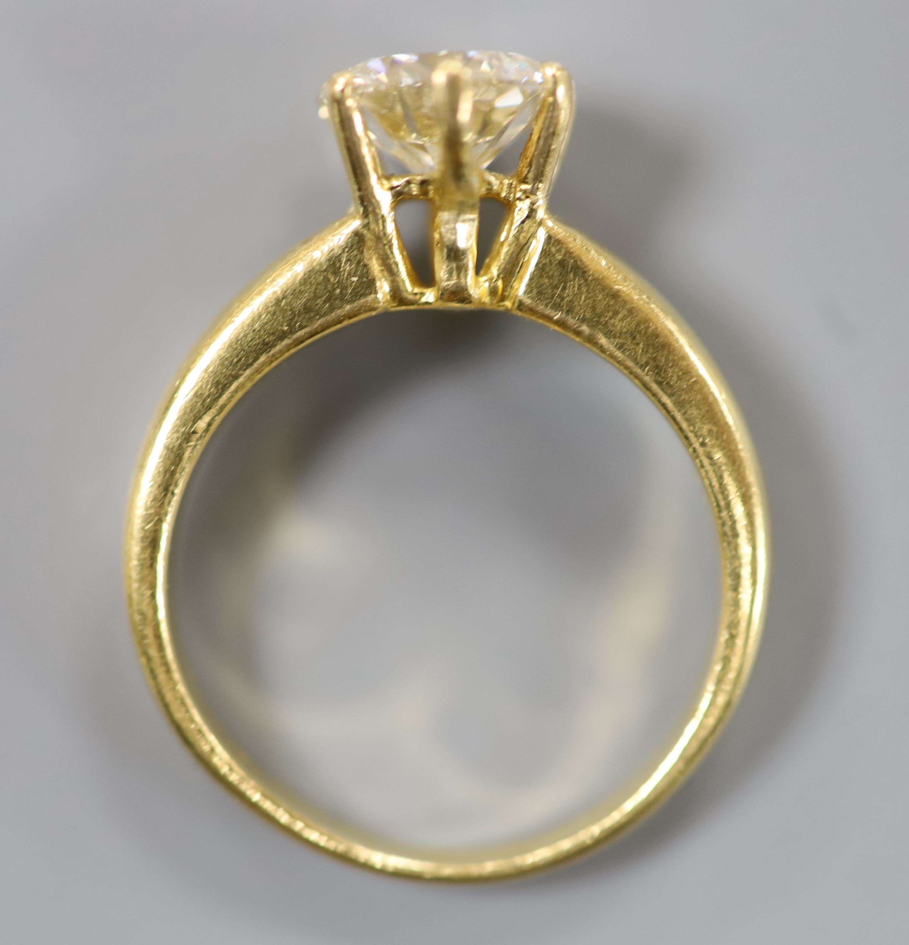 A yellow metal and solitaire diamond ring.